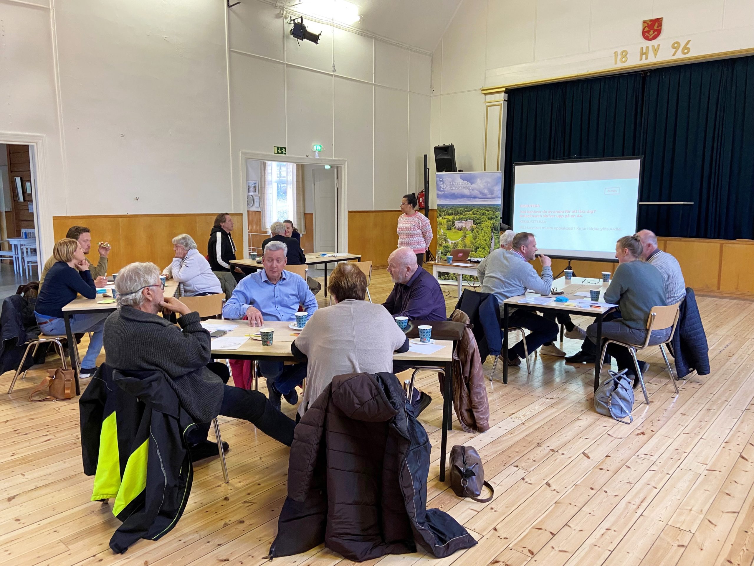 workshopsdeltagare sitter runt bord och jobbar i en ungdomslokal i Bromarv