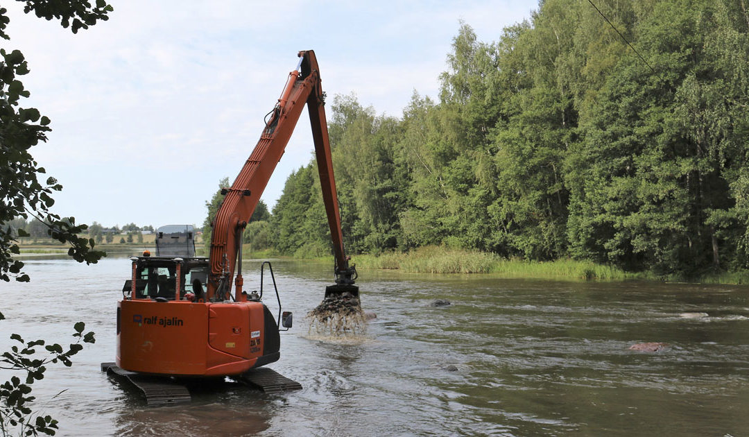 En grävmaskin muddrar i åfåran