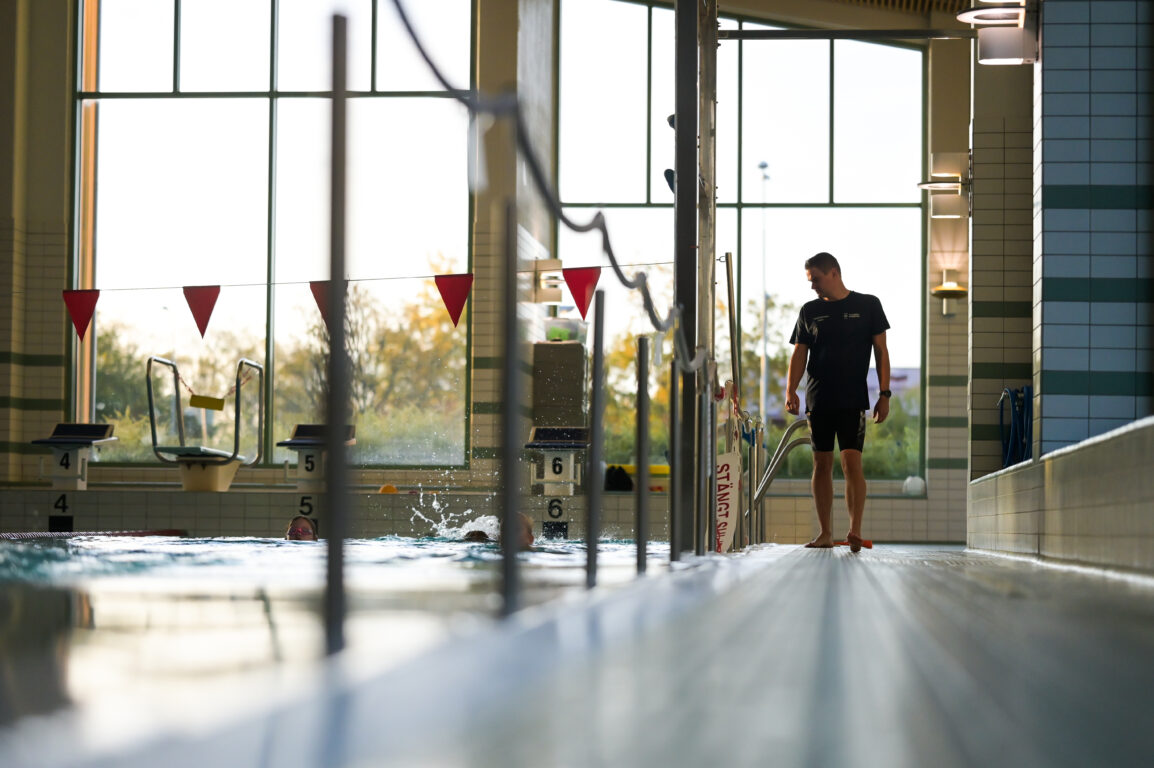 Liikunnanohjaaja uimahallissa ohjaamassa uimakoulua