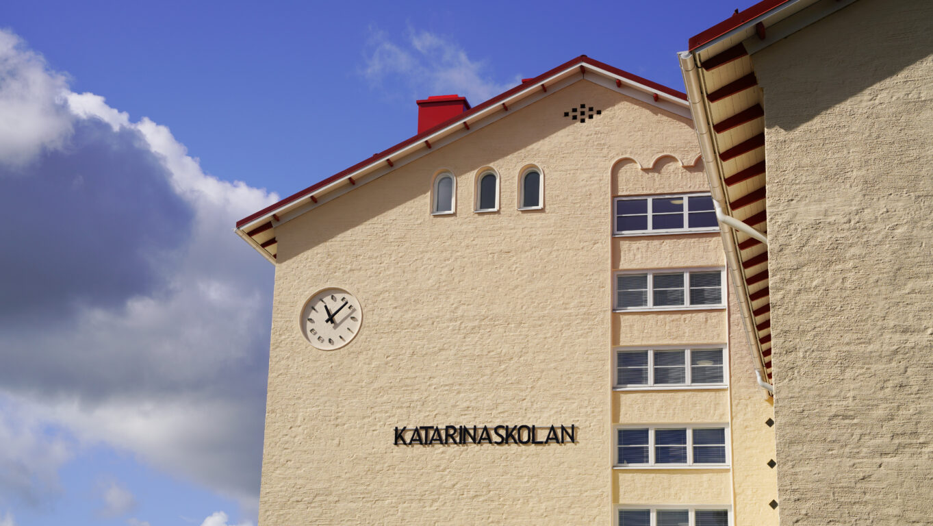 Katarinaskolans fasad med klocka och text Katarinaskolan